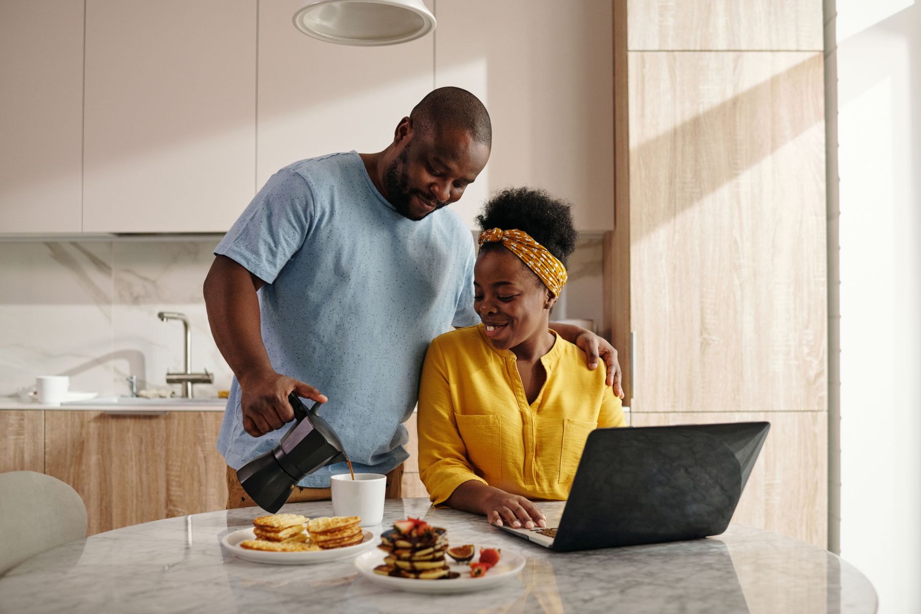 A couple checking life insurance rates on a laptop at their kitchen table